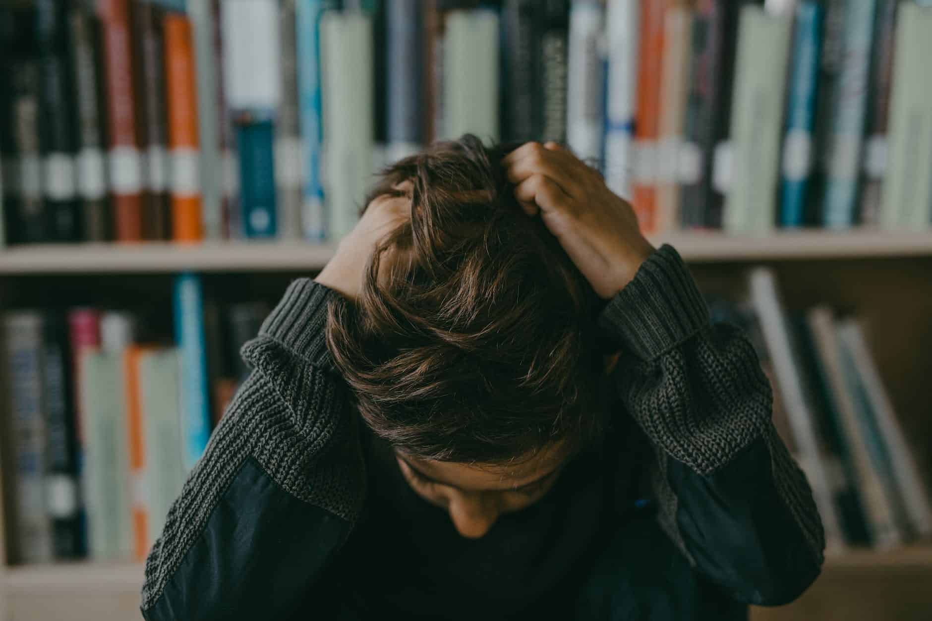 a boy wearing long sleeves sweater pulling his hair